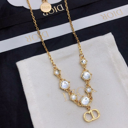 CD 26S CD LOGO CRYSTAL STATION NECKLACE IN GOLD TONE METAL WITH WHITE CRYSTAL 631006