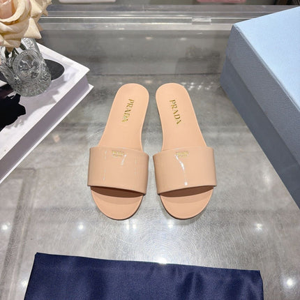 PRADA 26S LOGO EMBOSSED SLIDE SANDALS IN NUDE BEIGE PATENT CALFSKIN