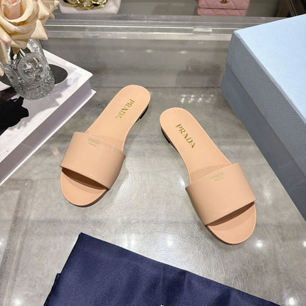PRADA 26S LOGO EMBOSSED SLIDE SANDALS IN NUDE BEIGE PATENT CALFSKIN