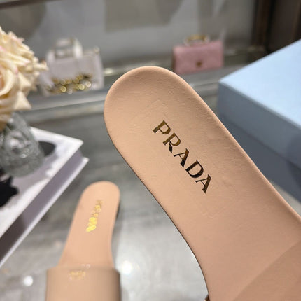 PRADA 26S LOGO EMBOSSED SLIDE SANDALS IN NUDE BEIGE PATENT CALFSKIN