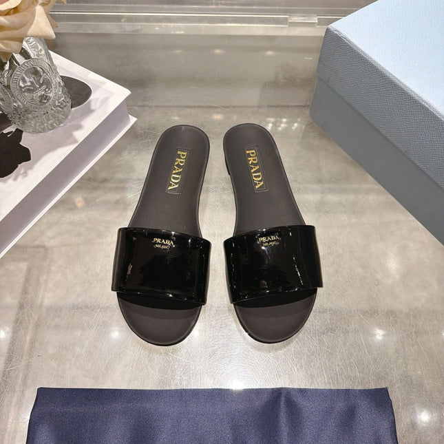 PRADA 26S LOGO EMBOSSED SLIDE SANDALS IN BLACK PATENT CALFSKIN
