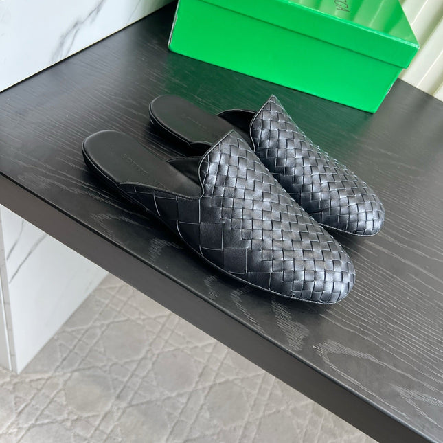BOTTEGA VENETA 26S FLAT MULES IN BLACK WOVEN LAMBSKIN