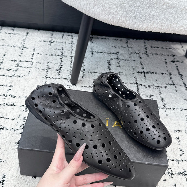 ALAIA 26S FLAT SLIP-ONS IN BLACK CALFSKIN WITH OPENWORK PATTERN