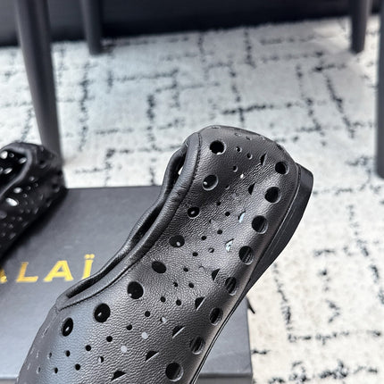 ALAIA 26S FLAT SLIP-ONS IN BLACK CALFSKIN WITH OPENWORK PATTERN