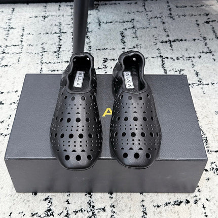 ALAIA 26S FLAT SLIP-ONS IN BLACK CALFSKIN WITH OPENWORK PATTERN