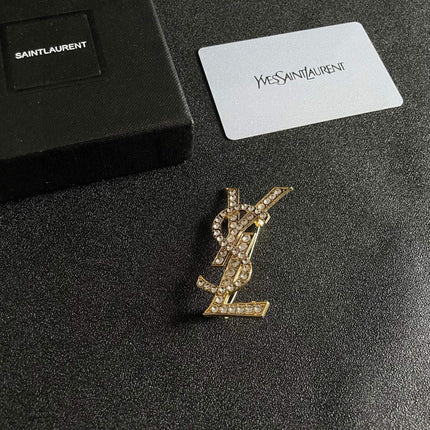 YSL 26S CRYSTAL MONOGRAM BROOCH IN GOLD TONE METAL 631043
