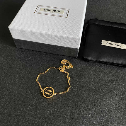 MIUMIU 26S LOGO ROUND BRACELET IN BLACK ENAMEL AND GOLD TONE METAL 631809